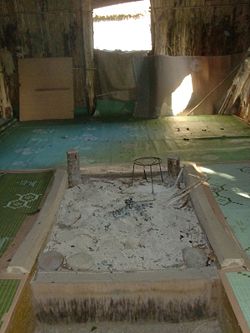 The interior of this replica Ainu dwelling shows where food was prepared. In the background is a special opening that acted as a separate entrance for Ainu spirits.