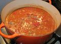 Canned tomatoes and canned, unflavored tomato sauce have been added and are ready to begin cooking, along with a little red wine.